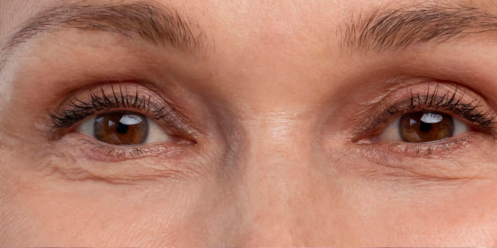 Close-up of a person's brown eyes with visible lashes and surrounding skin texture, looking slightly to the left and right.